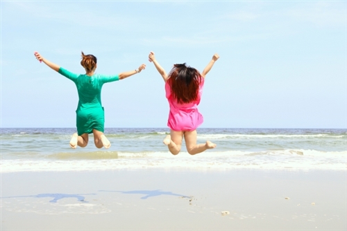 砂浜でジャンプしてる女性二人